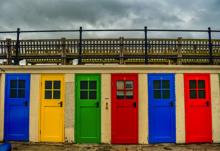Een kleurrijke rij strandhuisjes met gekleurde deuren in het schilderachtige North Berwick, Schotland.
